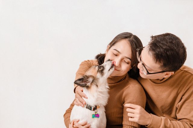Two%20people%20holding%20a%20dog